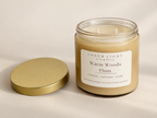 Warm Woods + Plum candle by Inner Light Creative with the lid removed, showing two wicks and a gold lid beside the oatmeal-colored jar.
