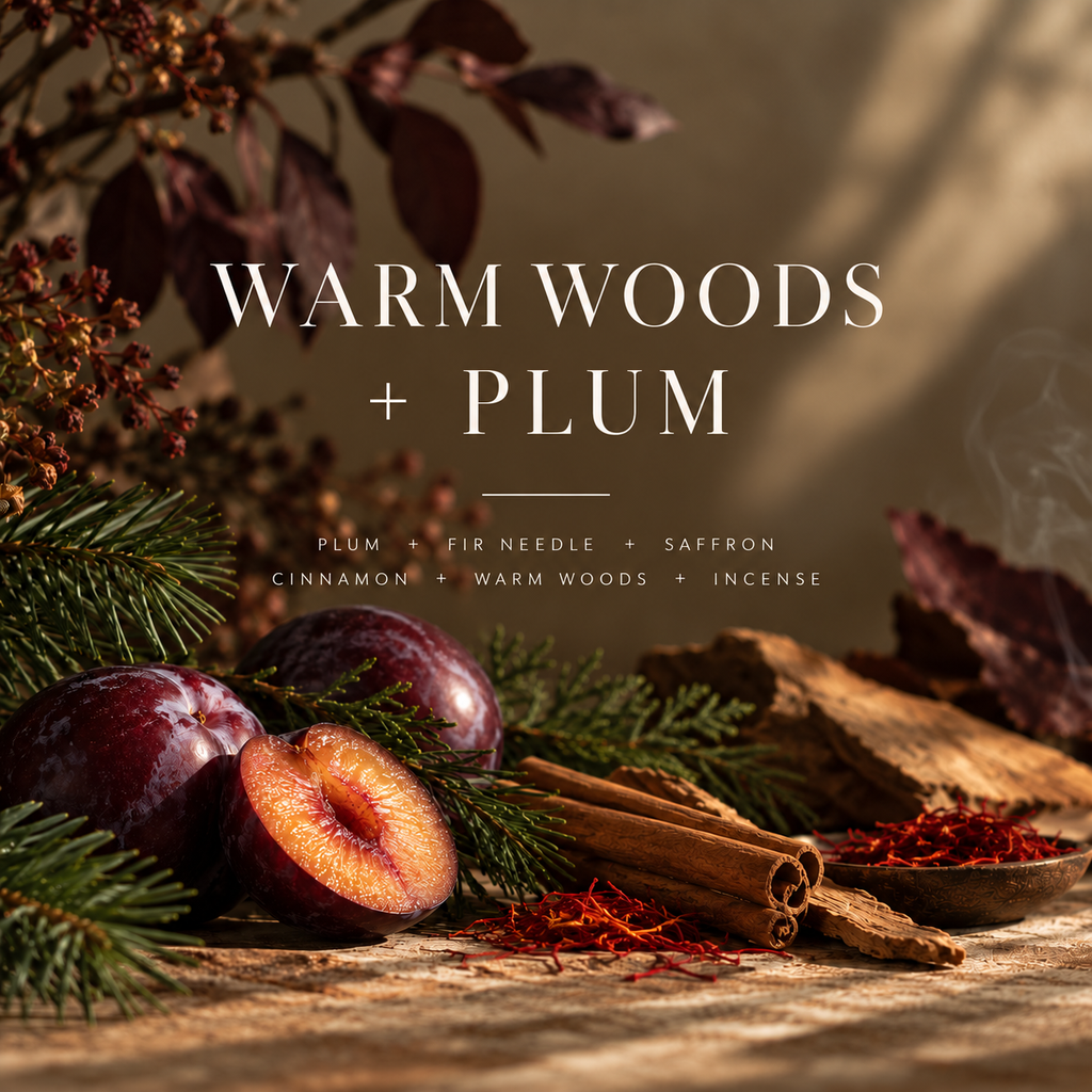Warm Woods + Plum fragrance card with plums, evergreen branches, cinnamon, saffron and wood, listing the candle’s scent notes.