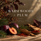 Warm Woods + Plum fragrance card with plums, evergreen branches, cinnamon, saffron and wood, listing the candle’s scent notes.